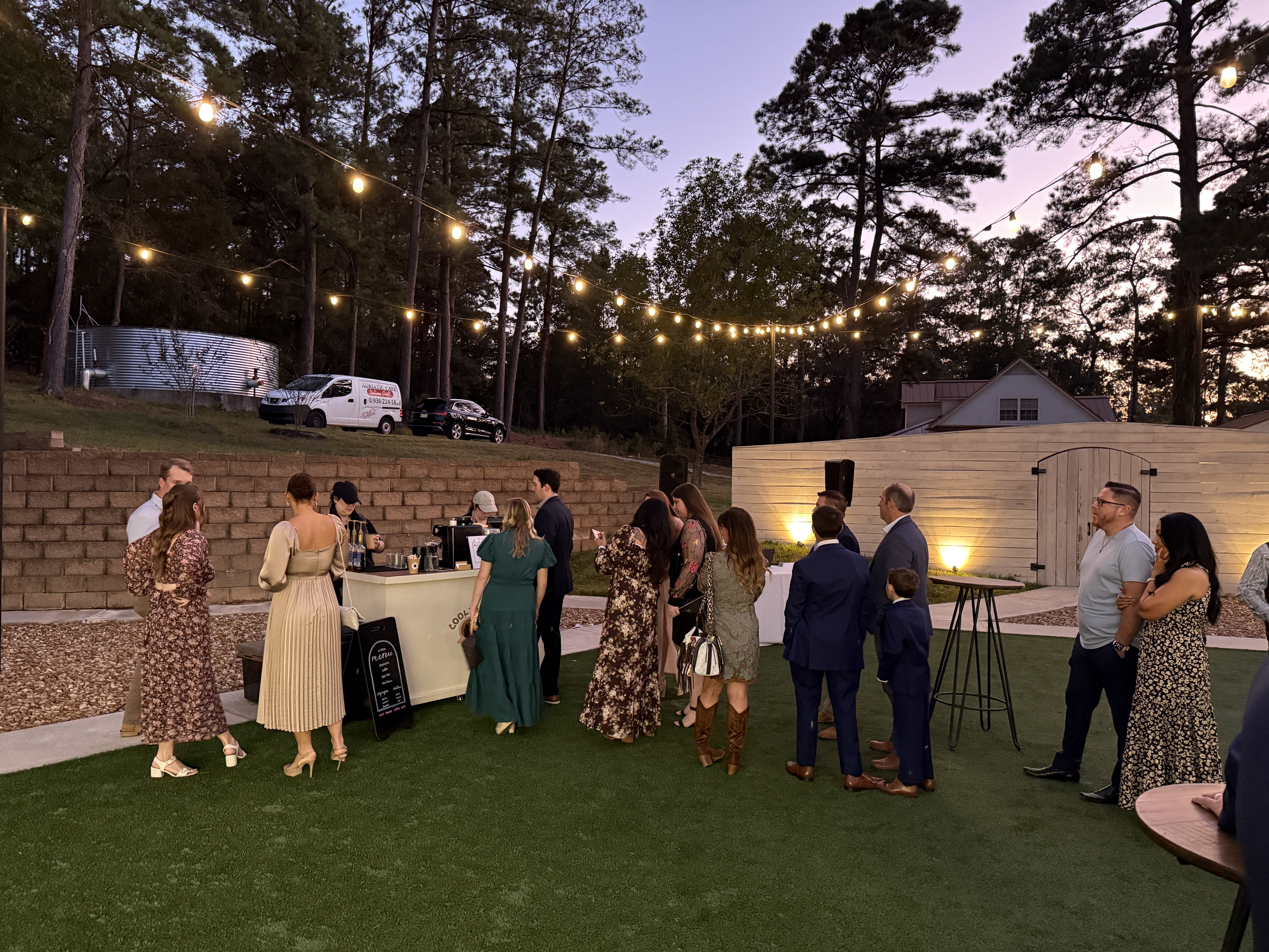Guests at an evening event with string lights